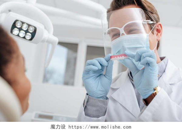 非洲裔美国妇女戴口罩戴乳胶手套的牙科医生选择重点口腔牙齿